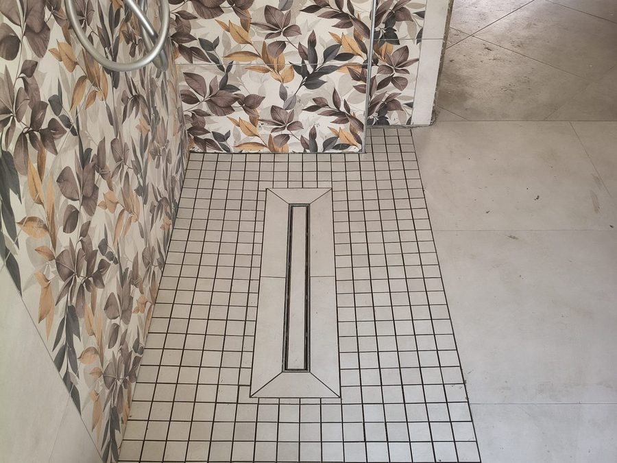 Doccia a filo pavimento in mosaico con scarico lineare