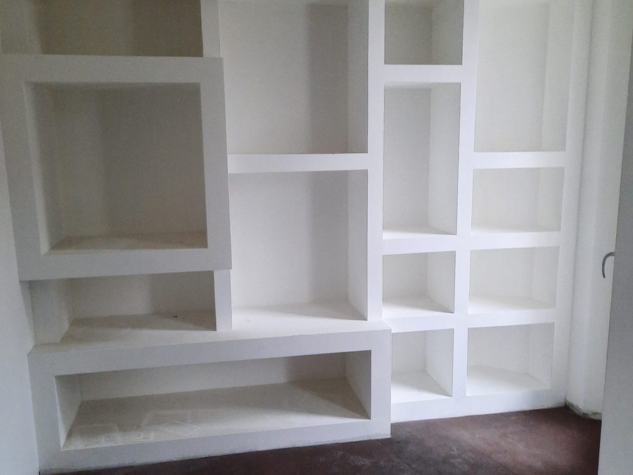 Libreria a muro bianca con vani di misure diverse